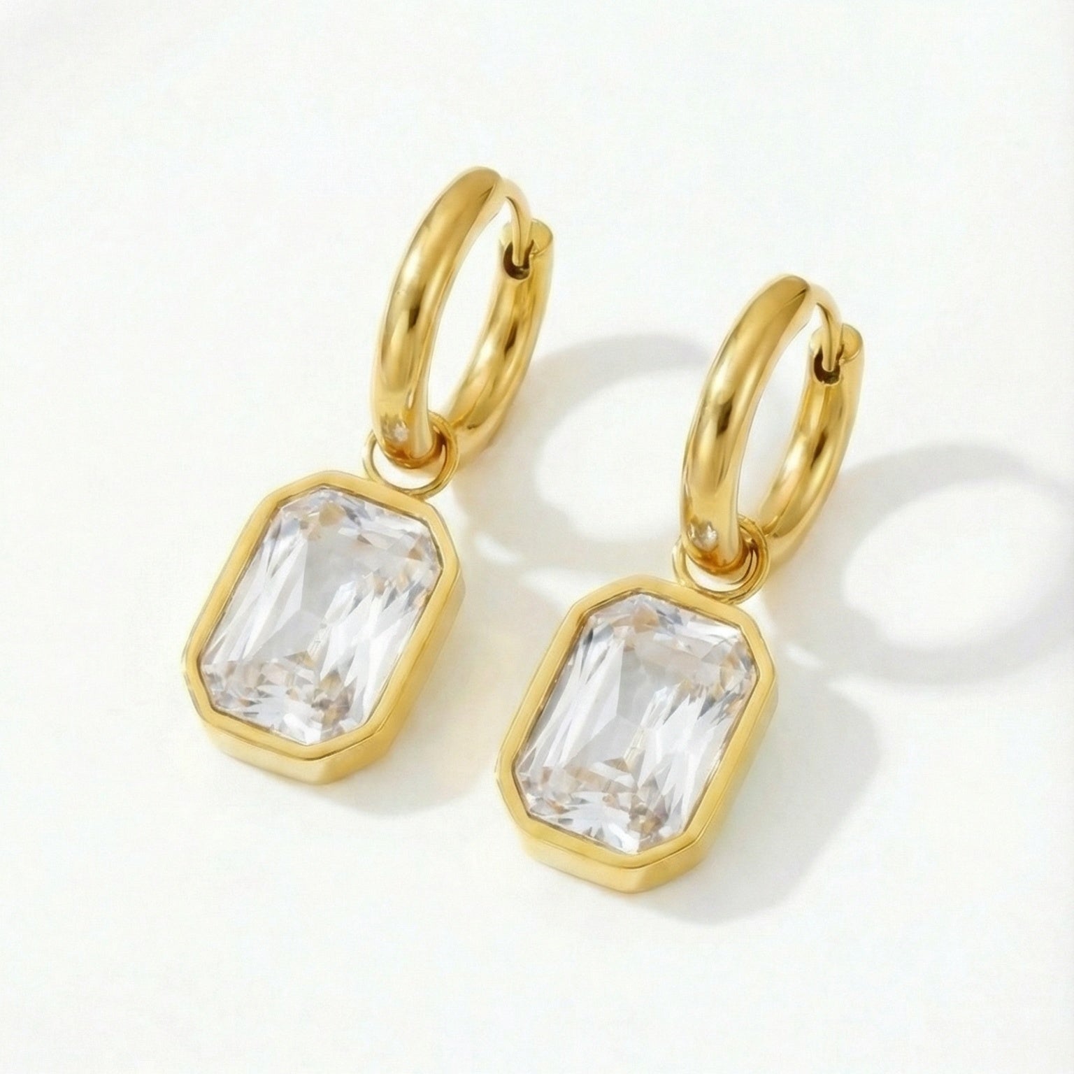 Elegant crystal cut earrings with sparkling facets, showcasing intricate designs and a silver-tone setting.