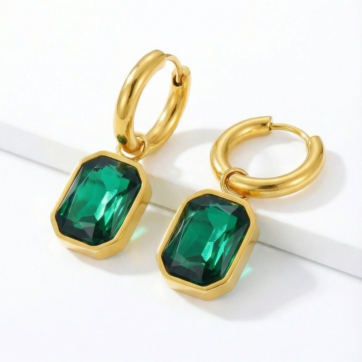 Elegant emerald cut earrings featuring sparkling gemstones and sleek silver settings, designed for sophisticated style.